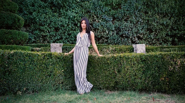 Portrait sophistiqué de jeune femme brune en plein air dans un parc . — Photo