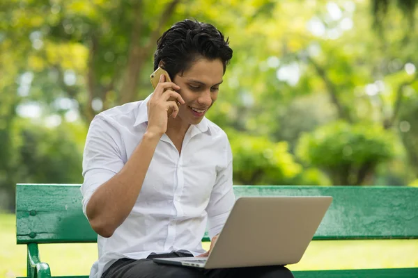 Jong Gelukkig Man Werken Met Laptop Praten Aan Telefoon — Stockfoto