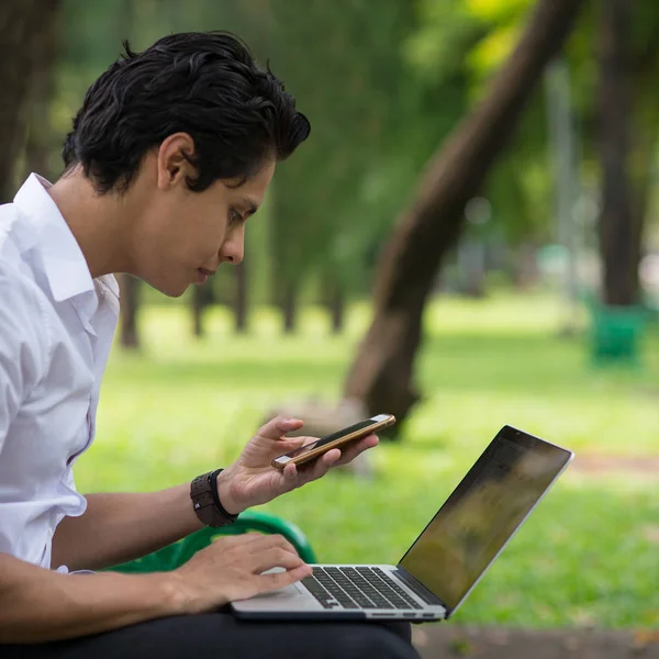 Jovem Homem Bonito Trabalhando Com Laptop Usando Smartphone Livre — Fotografia de Stock