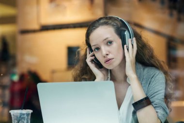 Dizüstü bilgisayarı ve dinleyicisi ile çalışırken iş kadını portresi