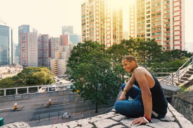 Sokakta dinlenen parkour adam Gülümseyen portre. Filtrelenmiş görüntü.