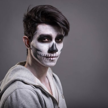 Kafatası stüdyoda genç adamın portresini makyaj. Gri arka plan.