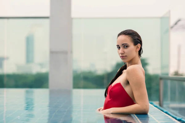 Selbstbewusste schöne Frauenporträt trägt roten Badeanzug in swimm — Stockfoto