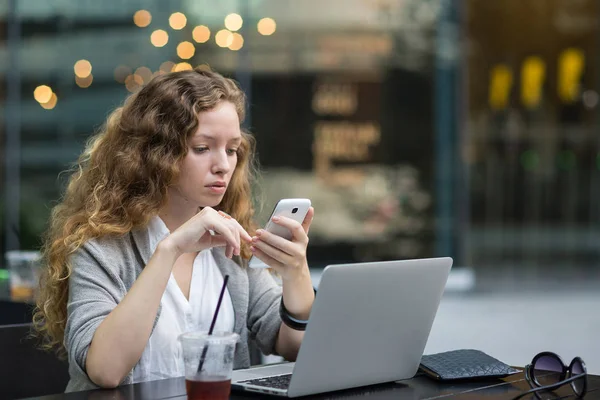 若いビジネスマンの女性の肖像画は バーで彼女のラップトップで作業中にスマートフォンでメッセージを送信します タイのバンコク — ストック写真