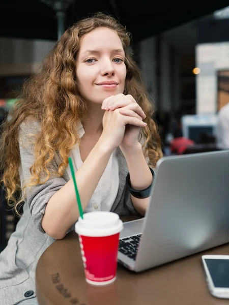 Jovem mulher de negócios com bebida quente e laptop dentro de café — Fotografia de Stock