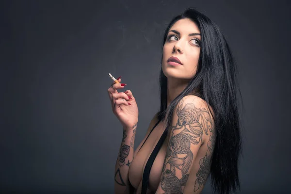 Закрыть портрет красивой женщины с татуировкой курение, носить — стоковое фото