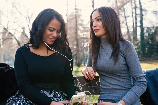 Young Sisters Relaxing Listening Music Smartphone Together Park — Foto Stock