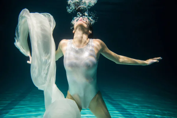 Underwater woman portrait in swimming pool at night. Dreamlike i — Stock Photo, Image