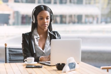 Milano'da dizüstü bilgisayarla çalışan kulaklıklı iş kadınlarını yoğunla.