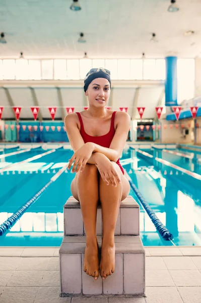 Smiling portrait of woman professional swimmer wearing red swims — Stock Photo, Image