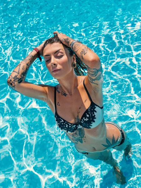 性感纹身女人的肖像穿着比基尼在游泳池内 — 图库照片