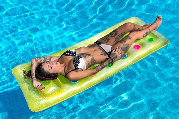 Sexy tattooed woman full body portrait wearing bikini relaxing l