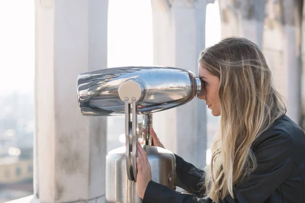 Joven adolescente rubia mirando la vista de la ciudad con binoc — Foto de Stock