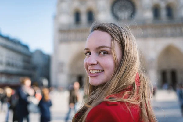 Young blonde woman smiling portrait with Notre Dame Cathedral in — Stockfoto