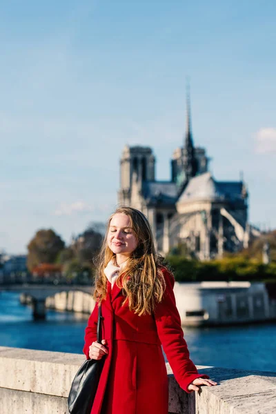 Young blonde woman relaxing with Notre Dame Cathedral in the bac — Stockfoto