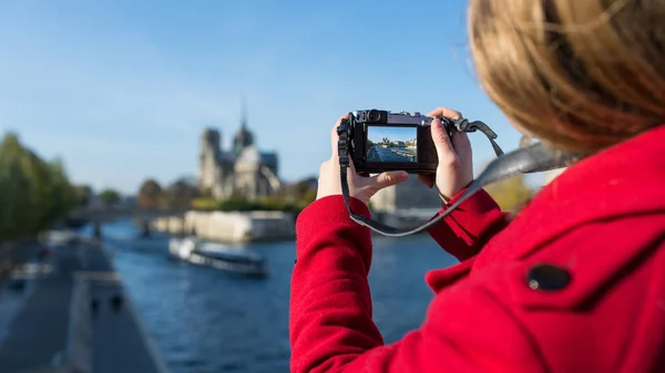Young blonde woman taking picture of Notre Dame Cathedral with p — 스톡 사진