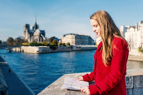 Mladá blondýna žena při pohledu na mapu s katedrálou Notre Dame v t — Stock fotografie