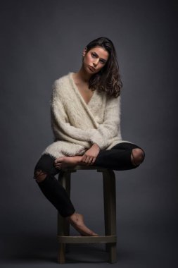 Gri arka plan karşı güzel samimi genç kadın stüdyo portre.