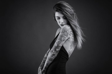 Uzun siyah elbise ve dövmeler ile Samimi kadın portresi. Siyah