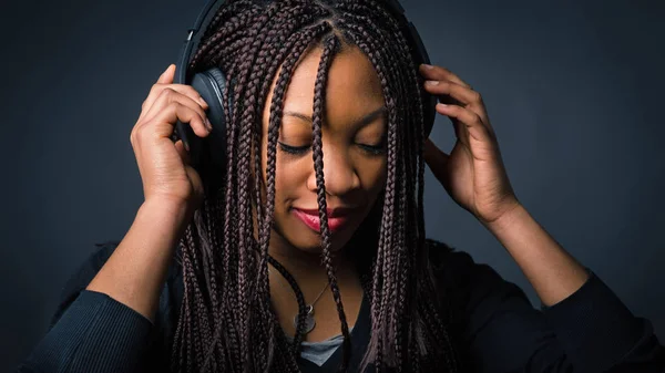 Αφρικανική νεαρή γυναίκα στούντιο πορτρέτο με πλεξούδες ακούγοντας μους — Φωτογραφία Αρχείου