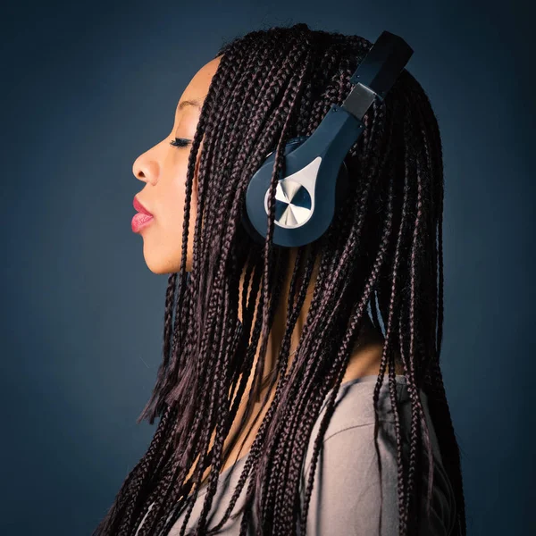 Africana giovane donna studio ritratto con trecce ascoltando mus — Foto Stock