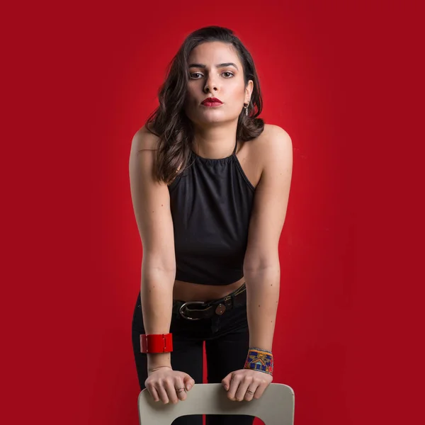 赤い背景に美しい若い女性 ファッションスタジオの肖像画 — ストック写真