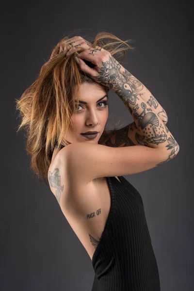 Portrait intime de femme en studio avec longue robe noire et tatouages — Photo