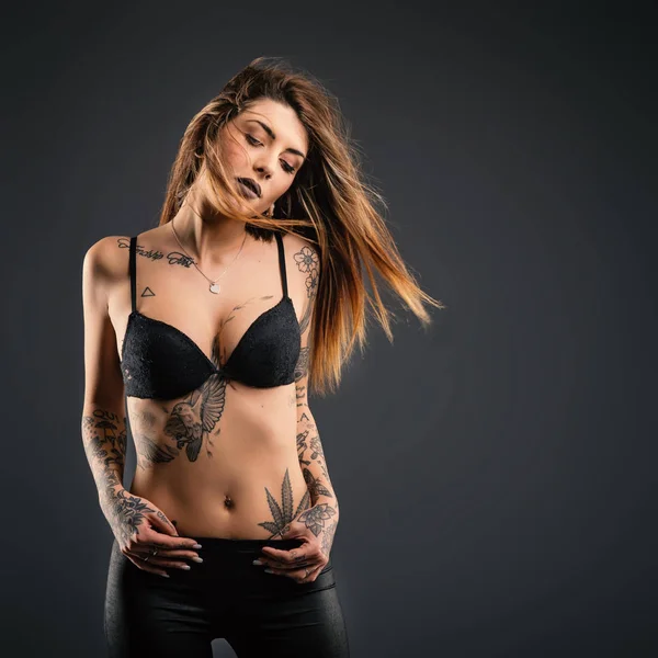 Vacker kvinna Studio porträtt med tatuering mot svart bakgr — Stockfoto