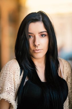 Piercing portre açık havada yoğun esmer genç.