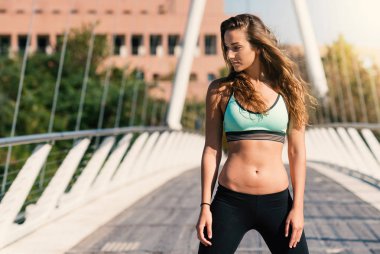 Kendine güvenen genç sportif kadın portre modern bir köprü üzerinde açık havada. 