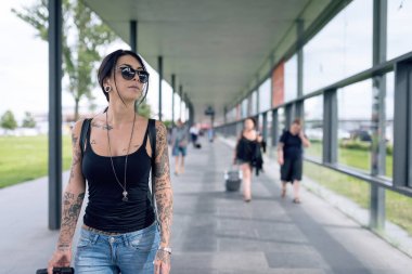 Berlin havaalanında genç esmer dövmeli kadın portresi.,