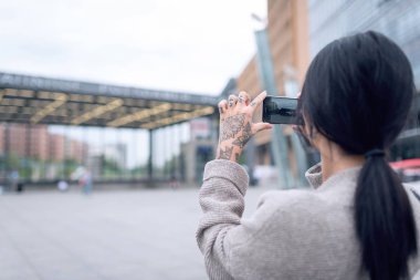 Potsdamer Platz 'ın fotoğrafını çeken genç bir kadın. Berlin, Almanya.