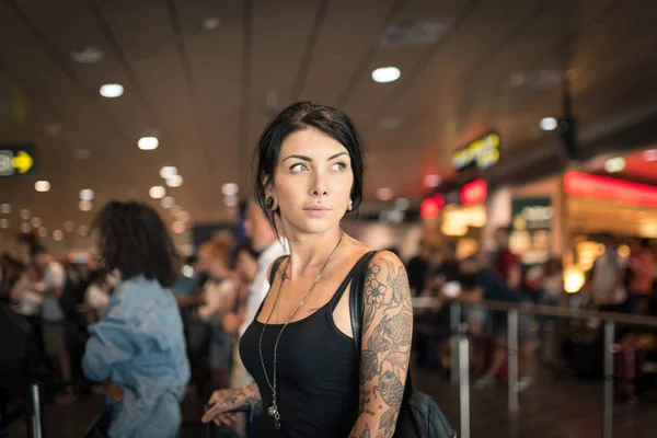 Junge brünette tätowierte Frau Porträt am Flughafen. — Stockfoto