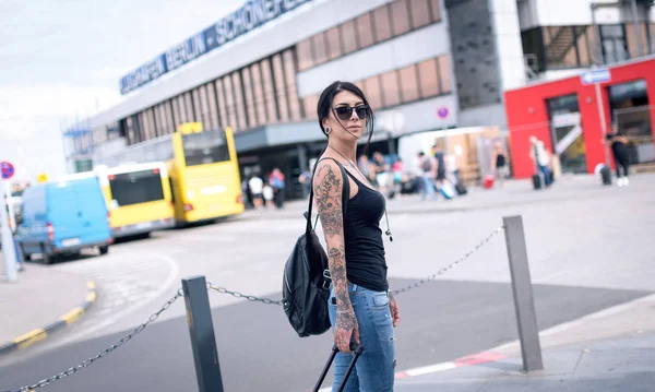 Young brunette tattooed woman portrait at the airport in Berlin, — Stockfoto