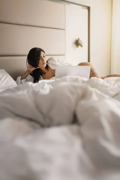 Sinnliche junge Frau Nahaufnahme Porträt liegt auf ihrem Bett und usin — Stockfoto