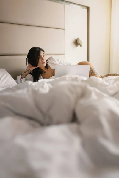 Sensual young woman close up portrait laying on her bed and usin — Stock Photo, Image