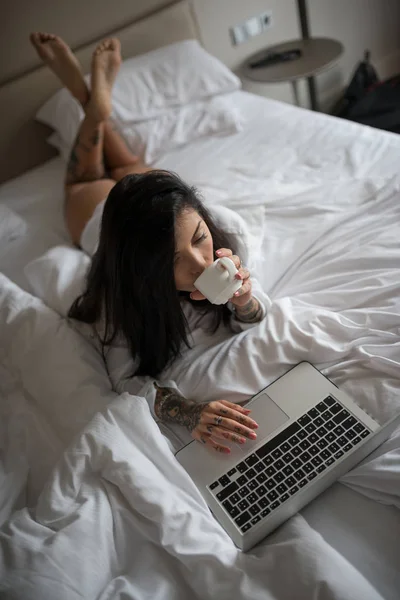 Sensual young woman close up portrait laying on her bed and usin — Stock Photo, Image