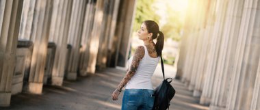 Nationalga 'da sütunların altında yürüyen çekici genç bir kadın.