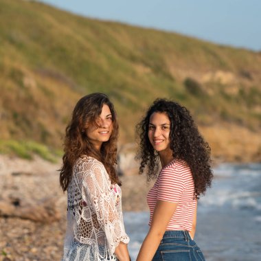 Genç kız kardeşler denizde birlikte yürürken portre çizerler. Yaşam tarzı kavramı.