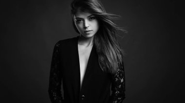 Siyah ceket giyen uzun saçlı kendine güvenen güzel kadın stüdyo portre. Siyah beyaz görüntü.