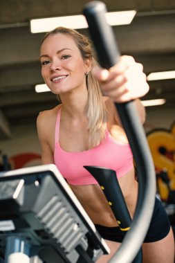 Young sporty woman smiling portrait working out in the gym. Concept of active lifestyle.
