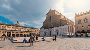 Bologna, İtalya - Circa Mart, 2018: Güneşli bir günde San Petronio Katedrali önünde yürüyen insanlar.