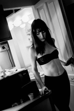 Seksi kadın özel portre siyah iç çamaşırı giyen evde kendini hazırlanıyor. Film tane efekti ile siyah beyaz yaşam tarzı görüntüsü. 