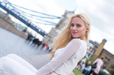 Arka planda Tower Bridge ile Londra'da Gülümseyen sarışın kadın portre.