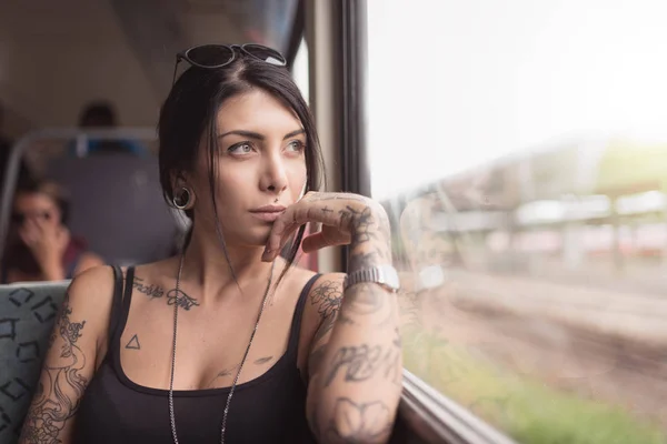 Young woman portrait inside a train looking out of the window. L — 스톡 사진