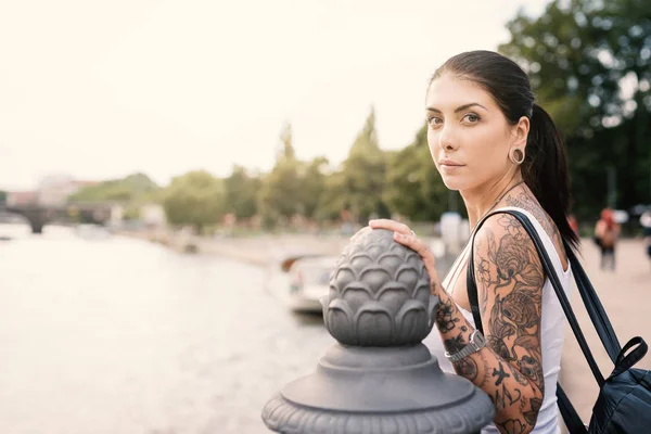 Young brunette tattooed woman with river in the background at su — Stock Photo, Image