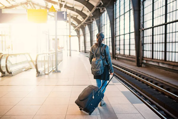 Tren istasyonunda tramvayla yürüyen genç kadın portresi. — Stok fotoğraf