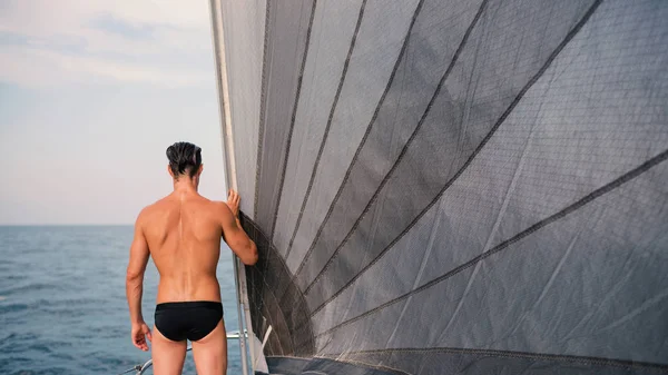 Yelkenli teknede denize bakan genç adam portresi. Buradan görüntüle