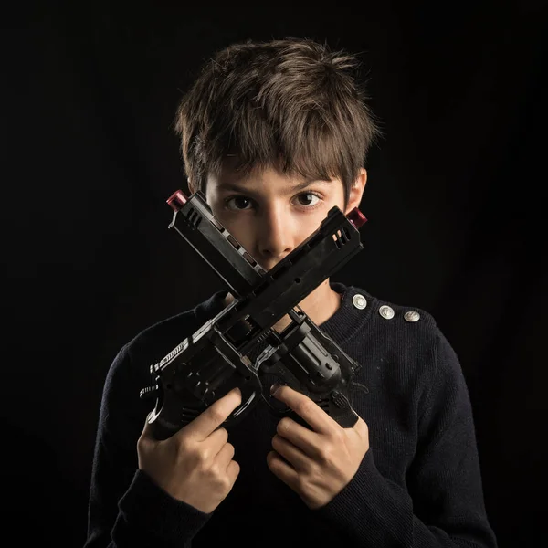 Fierce Kid Holding Korsade Kanoner Studio Porträtt Mot Svart Bakgrund — Stockfoto