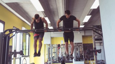 Two sporty men portrait working out in the gym. Concept of active lifestyle.
